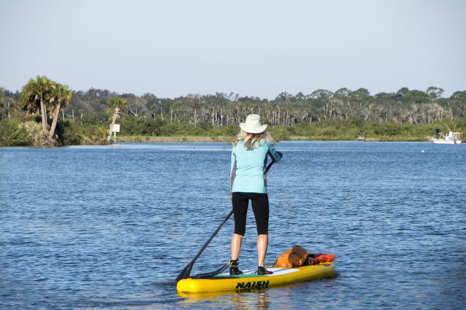 A beachgoer paddle-boarding at Daytona