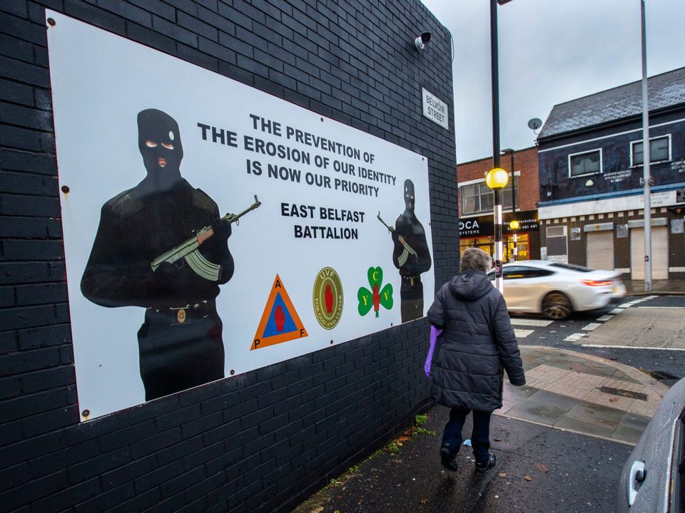 .A woman walks past a banner in support of Ulster loyalist paramilitary group the Ulster Volunteer Force (UVF) east Belfast Battalion. Picture date: Tuesday November 30 2021. PA Photo.