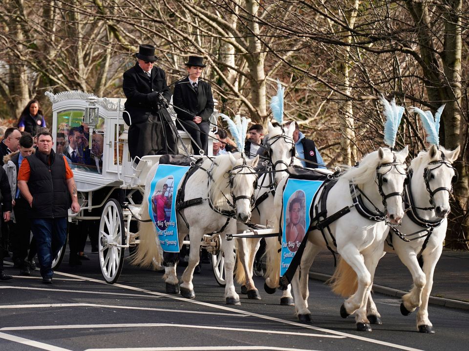 The horse-drawn carriage carrying the coffin of John Keenan arrives for his funeral at the Church of the Resurrection, Ballinfoyle in Galway. Photo: Niall Carson/PA