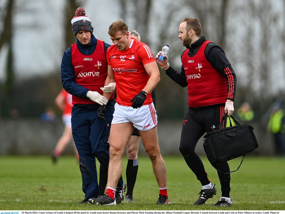 19 March 2023; Conor Grimes of Louth is helped off the pitch by Louth team doctor Ronan Kearney and Physio Mick Fanning during the Allianz Football League Division 2 match between Louth and Cork at Páirc Mhuire in Ardee, Louth. Photo by Stephen Marken/Sportsfile