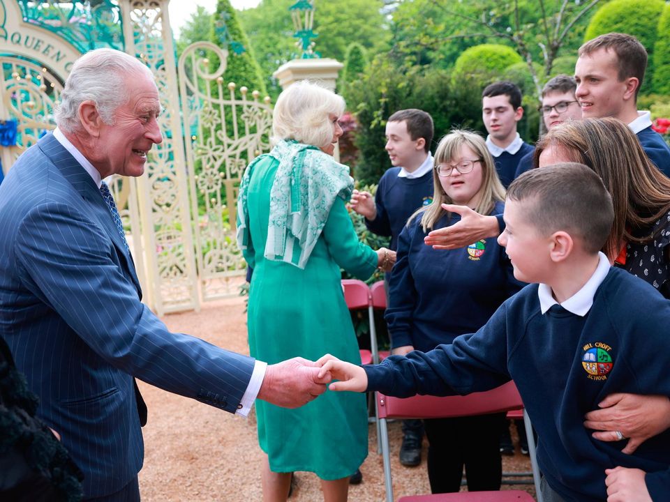 NEWTOWNABBEY, NORTHERN IRELAND - MAY 24: King Charles III and Queen Camilla greet school children during a visit to open the new Coronation Garden on day one of their two-day visit to Northern Ireland on May 24, 2023 in Newtownabbey, Northern Ireland. King Charles III and Queen Camilla are visiting Northern Ireland for the first time since their Coronation. Their Majesties will met designers of the Garden and representatives of community and charitable organisations, hearing how the Garden marks the beginning of a new green initiative for the Antrim and Newtownabbey Borough Council. (Photo by Chris Jackson/Getty Images)
