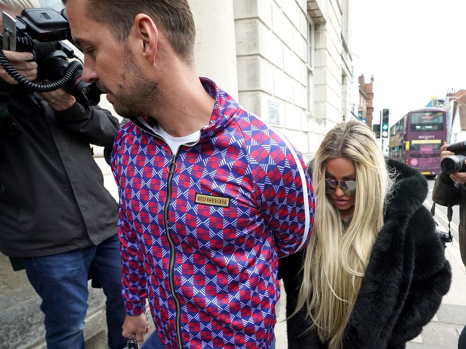 Katie Price outside court with fiance Carl Woods (Steve Parsons/PA)