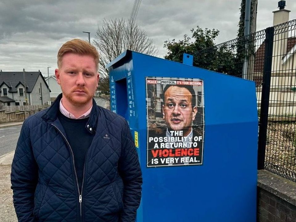 The SDLP's Daniel McCrossan pictured with one of the threatening posters