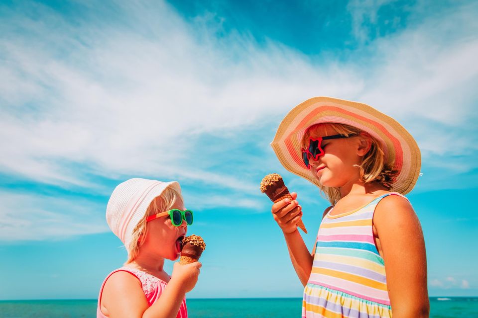Two girls enjoying an ice cream on the beach