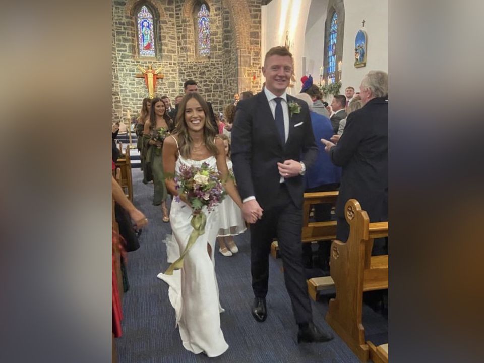 Joe Canning and Megan Hoare walking down the aisle together after tying the knot