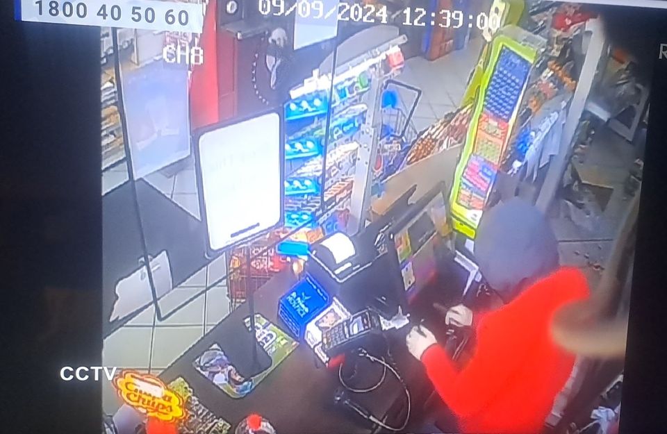 The man in the red hoodie attempts to open the till