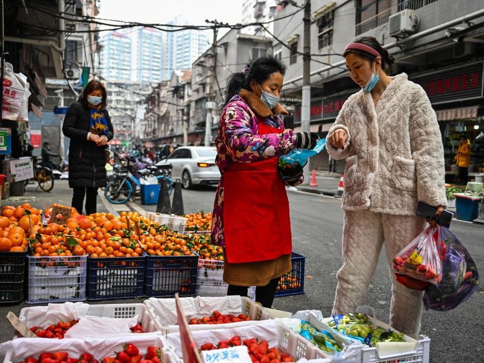 A customer buys fruit at a local market in Wuhan, in China's central Hubei province