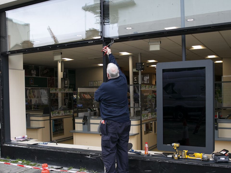 A workman outside the Aldi store in Rathmines after an incident in which a car smashed the window. Photo: Collins