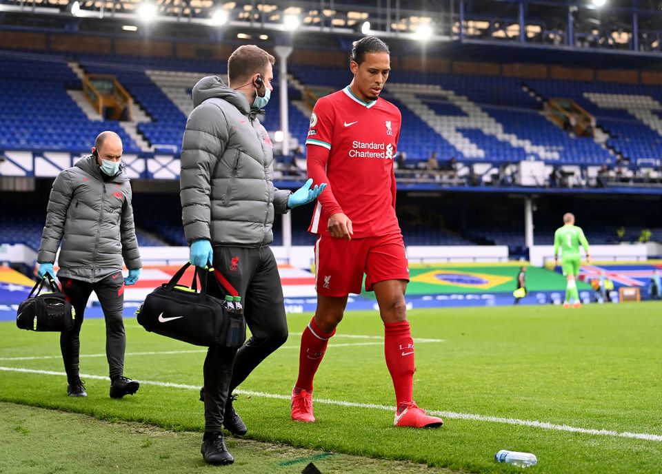 Liverpool’s Virgil van Dijk walks off the pitch after suffering a knee injury in a challenge by Everton goalkeeper Jordan Pickford during the Merseyside derby.