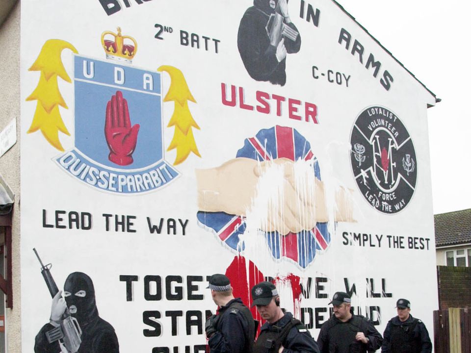 PACEMAKER, BELFAST, 6/2/2003:  PSNI officers walk past a defaced UDA mural in Boundary Way off the Shankill Road in Belfast this morning after the Adair family and supporters were forced to flee to Scotland overnight.