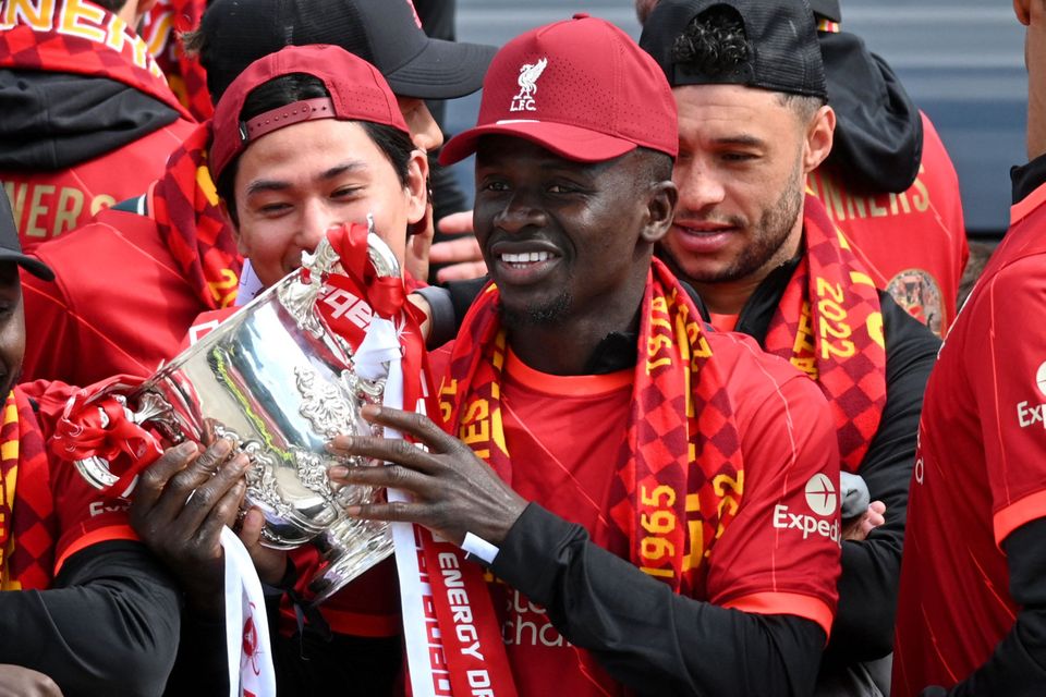 Liverpool's Sadio Mane holds the League Cup Trophy as he celebrates with temmates on an open-top bus