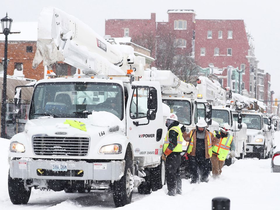 Electricity workers work to resupply power to homes in Buffalo, New York. Photo: Joseph Cooke/The Buffalo News via AP