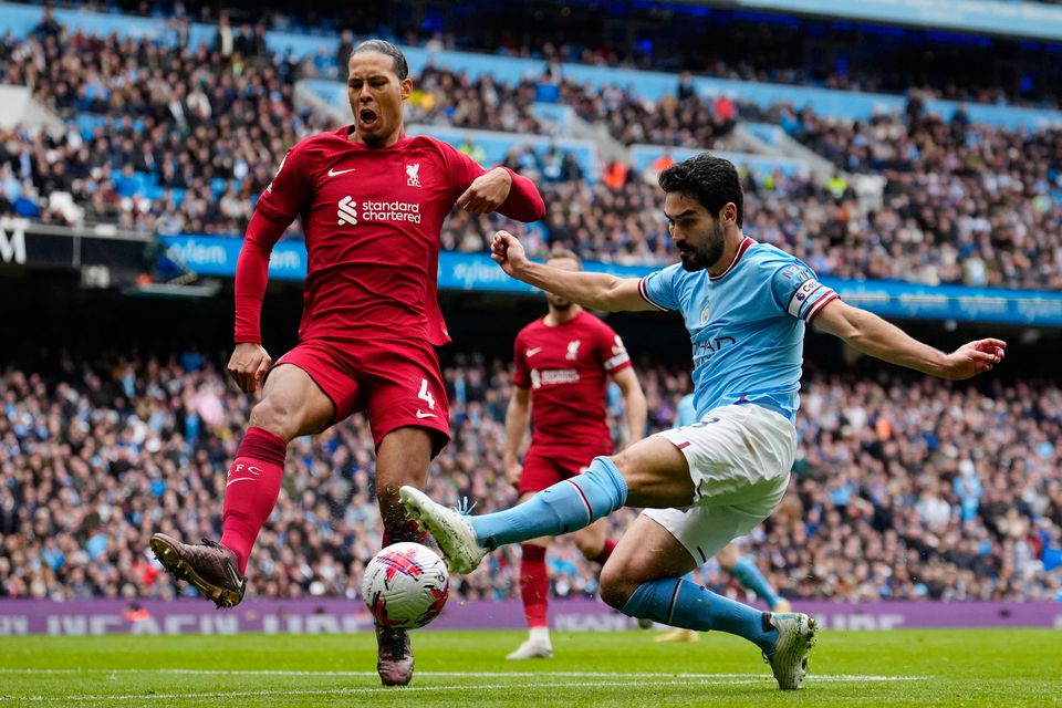 Manchester City's Ilkay Gundogan, right, challenged by Liverpool's Virgil van Dijk, scores their third goal. AP Photo/Jon Super