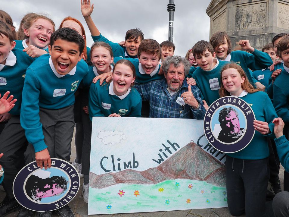 Charlie Bird pictured in Westport town centre with pupils from Scoil Pádraig who gave a recital for him ahead of the climb of Croagh Patrick. Photo: Gerry Mooney.