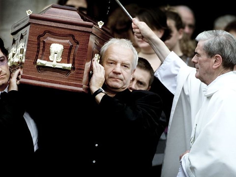 Bono and his brother Norman carry their father Bob's coffin