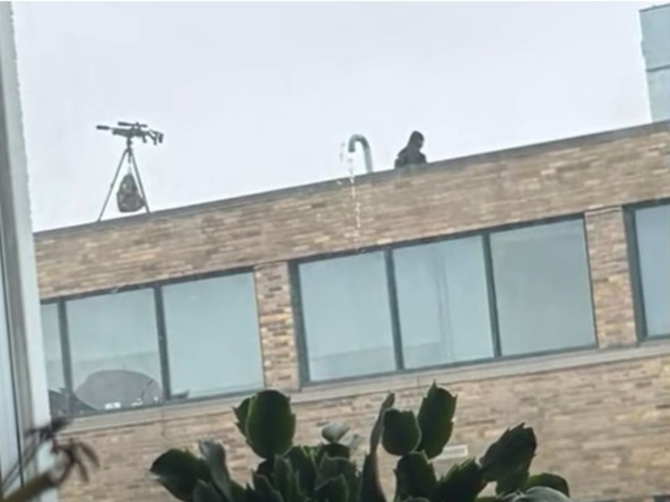 The sniper rifle can be seen attached to a tripod on the roof's building before it fell off. Photo: WIVB-TV/Andrew Mavrogeorgis