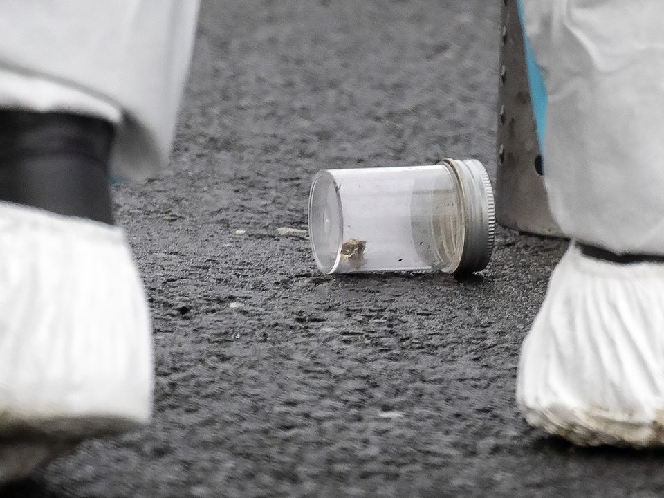A bullet casing inside a container is removed from the driveway of a house on Harelawn Park, Ronanstown. Photo: Colin Keegan, Collins Dublin