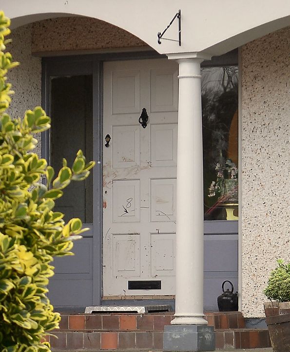 Blood smears are visible on the front door of the house in Castlebalney
