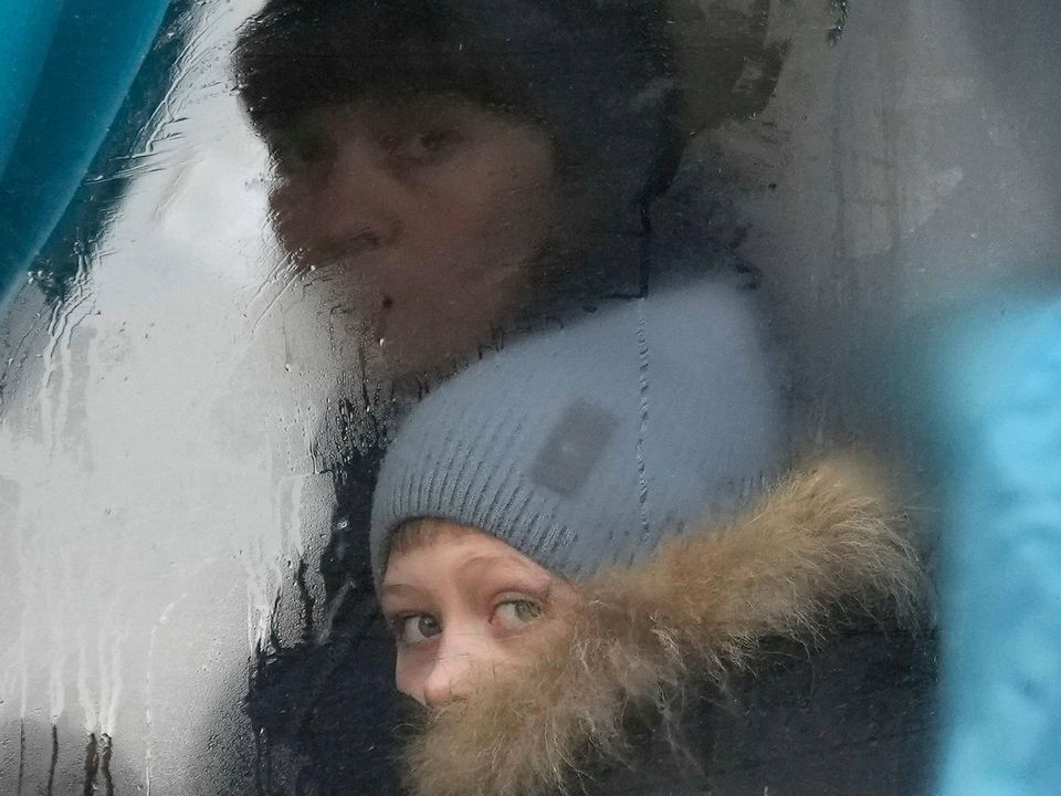 A woman and child peer out of the window of a bus as they leave Sievierodonetsk, the Luhansk region, in eastern Ukraine, Thursday, Feb. 24, 2022. Picture: Reuters