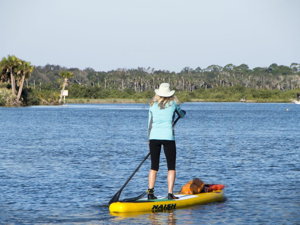 A beachgoer paddle-boarding at Daytona
