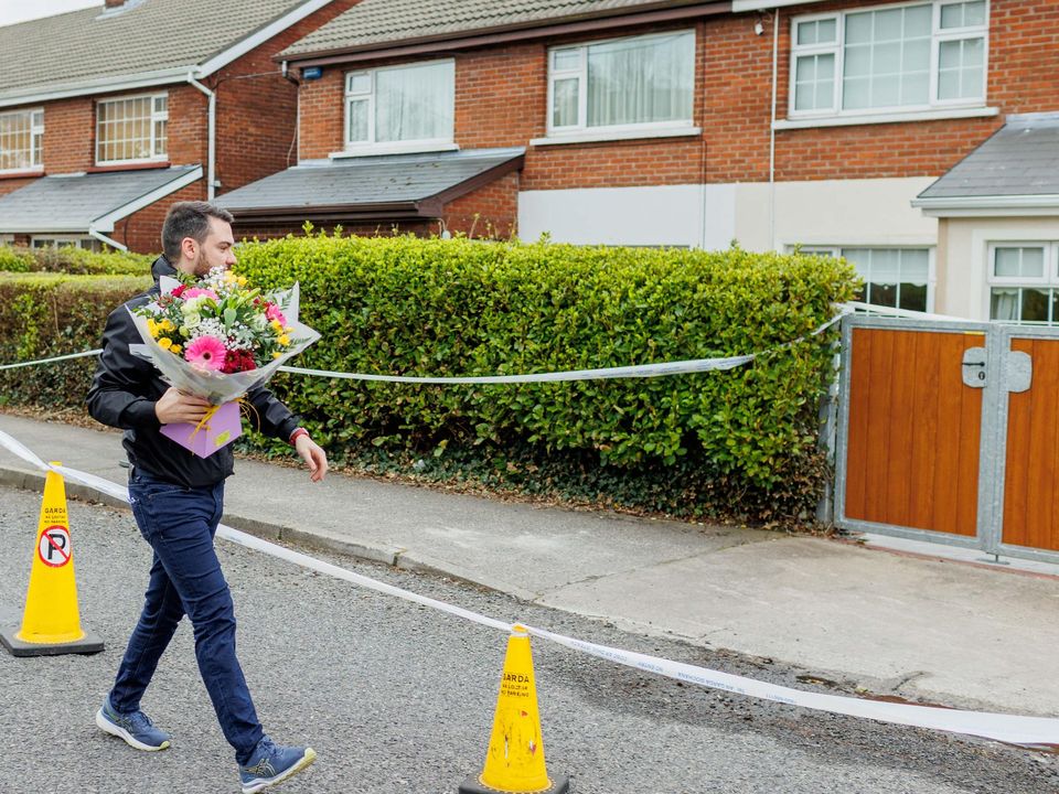 Local Fine Gael activist Blaine Gaffney arriving with flowers at the scene where the body of man in his 30s was found in house at Cartron, Sligo in ‘unexplained circumstances’ Photo: James Connolly