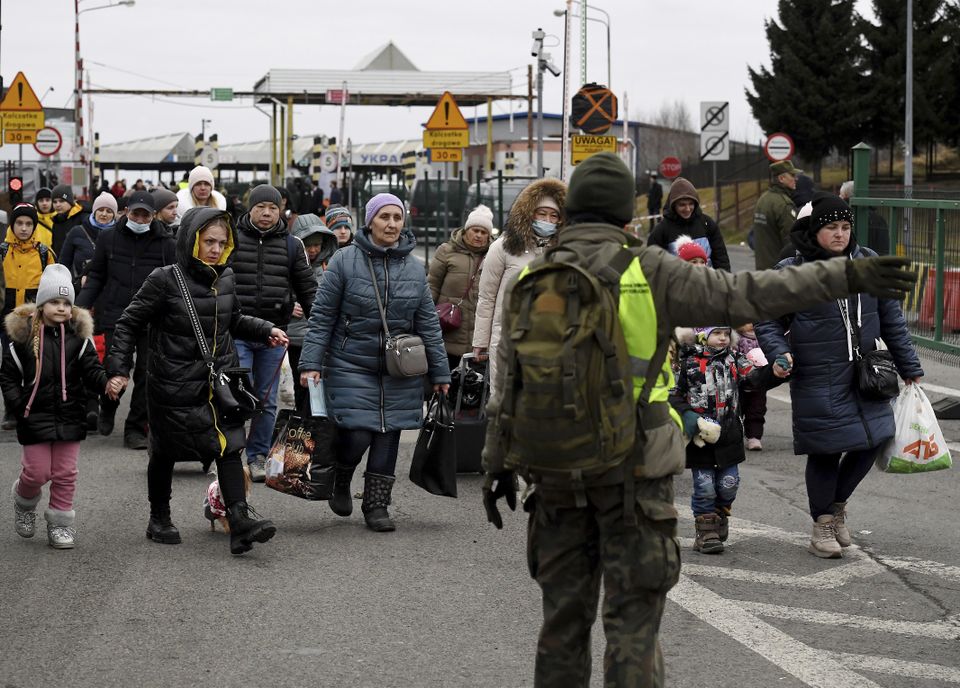Ukrainian citizens pass through the Polish border crossing in Korczowa, Poland (Olivier Douliery/AP)