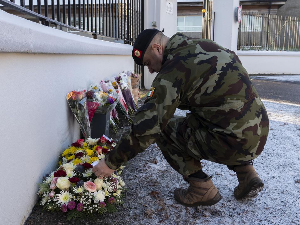 A member of the Defence Forces looks at flowers and tribute messages for Pte Sean Rooney outside Aiken Barracks in Dundalk. Photo: Colin Keegan, Collins