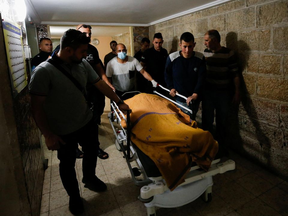 People carry the body of Palestinian woman Ghada Sabatin (47), who was killed by Israeli forces