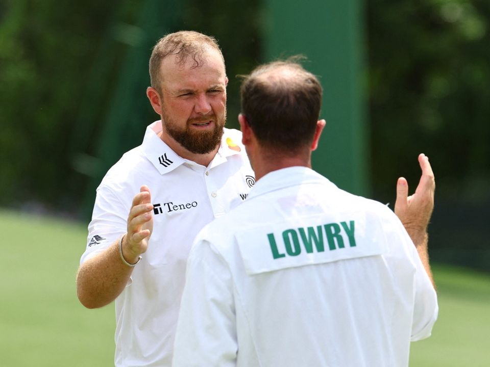 Ireland's Shane Lowry shakes hands with his caddie on the 18th green after completing his first round