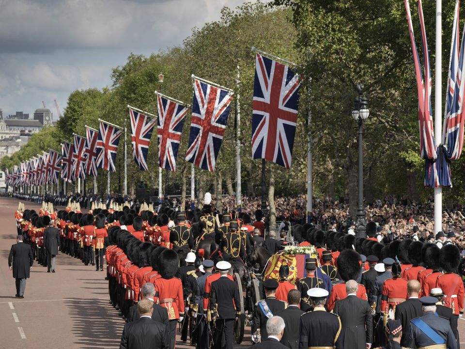 The coffin of Queen Elizabeth II, draped in the Royal Standard, is carried on a horse-drawn gun carriage of the King's Troop Royal Horse Artillery, during the ceremonial procession from Buckingham Palace to Westminster Hall, London. Picture date: Wednesday September 14, 2022.