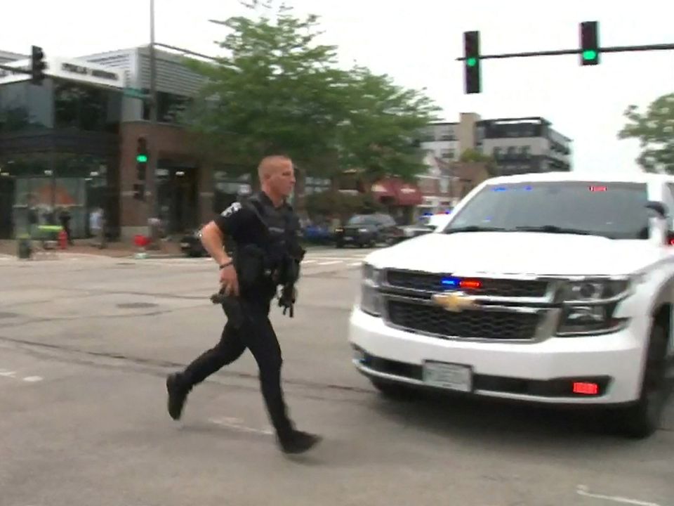 A police officer runs across a street after gunfire erupted at a Fourth of July parade route in the Chicago suburb of Highland Park, Illinois. Picture: Reuters