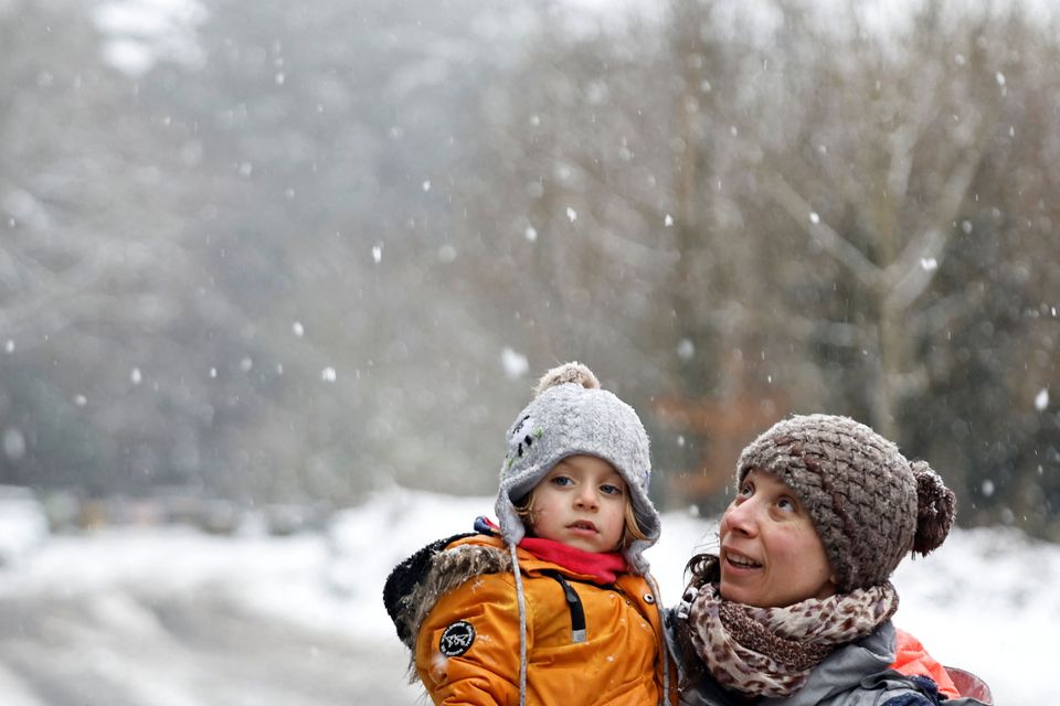 Gurusa Geraldo holds her son Conor Geraldo Furlong, 3, in Massey Woods during heavy snow, in Dublin, Ireland March 9, 2023. REUTERS/Clodagh Kilcoyne