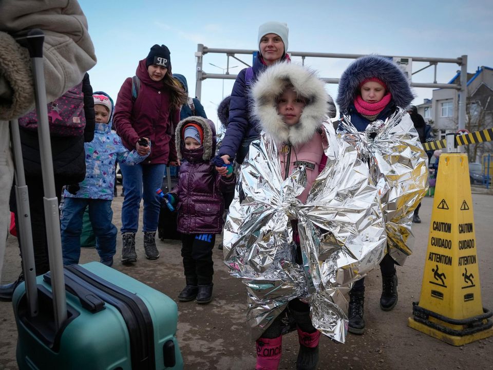 Refugees walk in a group after fleeing the war from neighbouring Ukraine at the border crossing in Palanca, Moldova, Thursday, March 10, 2022. (AP Photo/Sergei Grits)