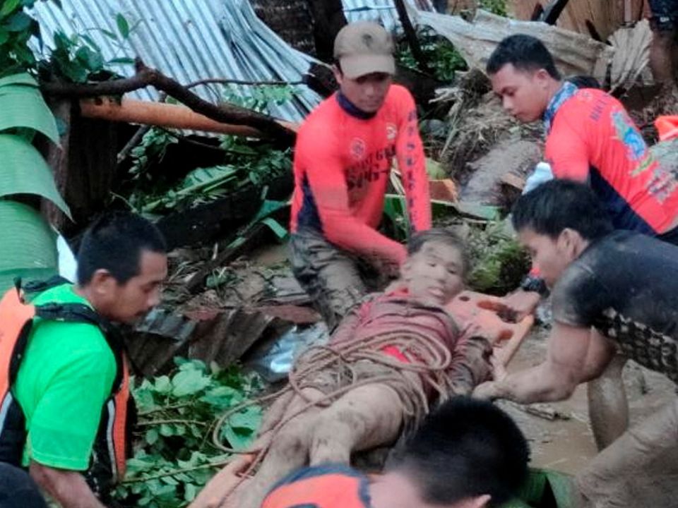 Rescuers carry a person injured in a landslide