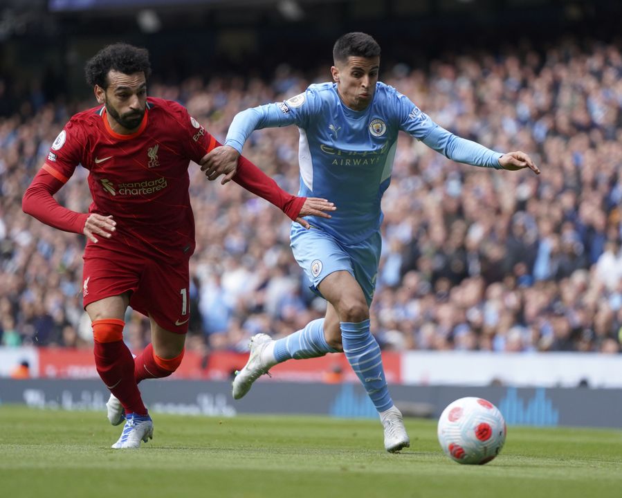 Mohamed Salah tussles for the ball with Joao Cancelo (Jon Super/AP)
