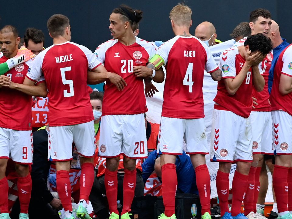 Denmark players make a wall around teammate Christian Eriksen being assisted by medics during the Euro 2020 soccer championship Group B match between Denmark and Finland at Parken Stadium in Copenhagen, Saturday, June 12, 2021. (Stuart Franklin/Pool via AP)