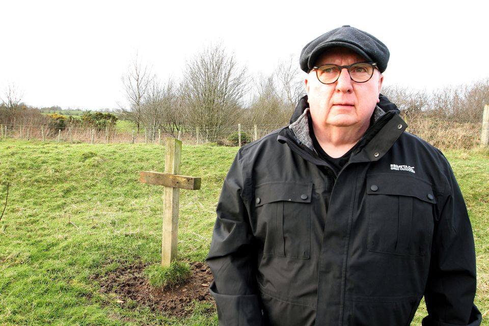 Reporter Hugh Jordon, stands beside a small wooden cross Davy Tweed had erected on land close to the family farm near Dunloy