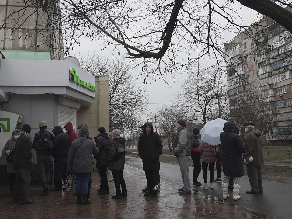 People line up to withdraw their money from an ATM in Mariupol, Ukraine (Evgeniy Maloletka/AP)