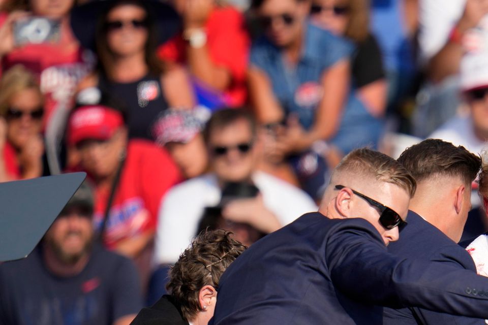 Donald Trump was helped off by bodyguards (Gene J. Puskar/AP)