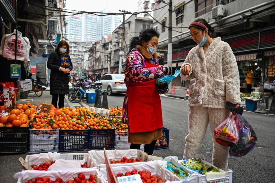 A customer buys fruit at a local market in Wuhan, in China's central Hubei province