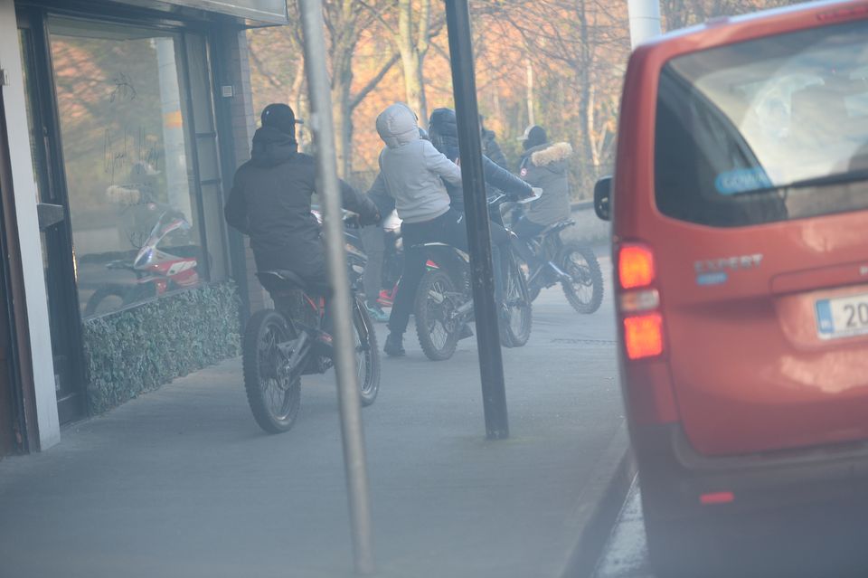 A number of youths on motorbikes outside the funeral