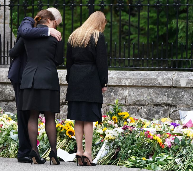 The Duke of York, Princess Eugenie and Princess Beatrice (right) view the messages and floral tributes left by members of the public Balmoral in Scotland following the death of Queen Elizabeth II on Thursday. Picture date: Saturday September 10, 2022.