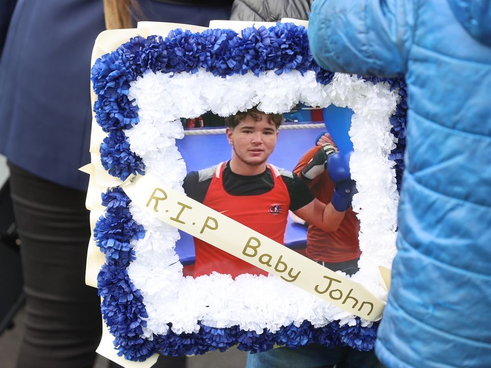 Mourners hold a photograph of John Keenan Sammon outside The Church of the Resurrection in Galway. Picture; Gerry Mooney