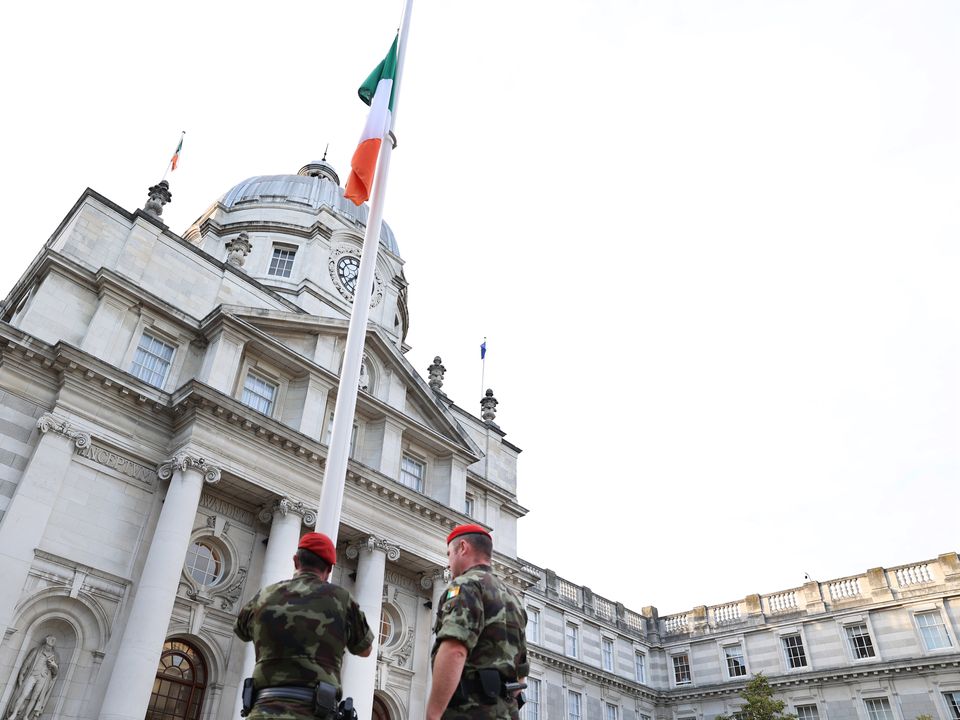 Members of the Irish Defence Forces military police lower the Irish flag to half mast outside Government Buildings in Dublin after the announcement of the death of Queen Elizabeth II
