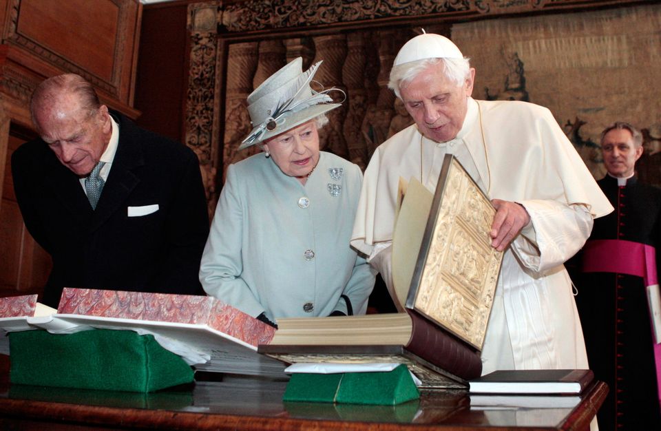 The Duke of Edinburgh looking on (left) as Queen Elizabeth II talks with Pope Benedict XVI.
Photo:  PA