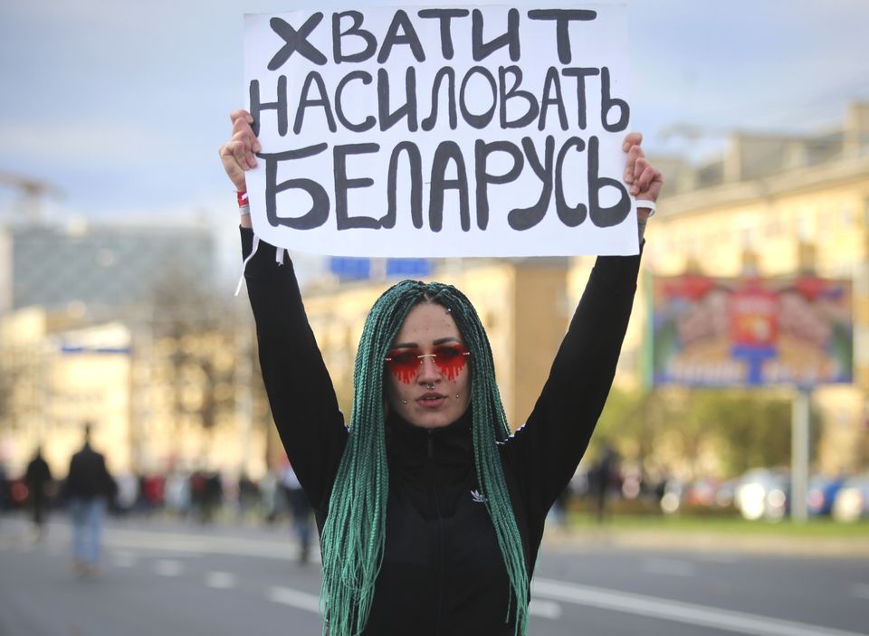 A protester in Minsk holds a sign that reads ‘Stop raping Belarus’ (AP)