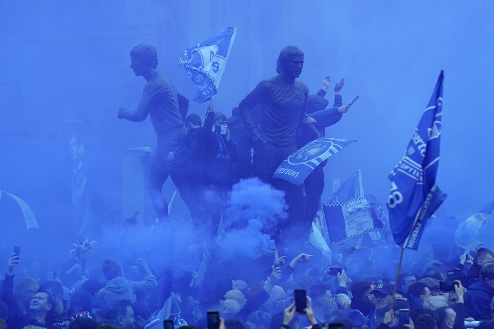 The arrival of the Everton players was greeted with blue smoke canisters (Jon Super/AP)