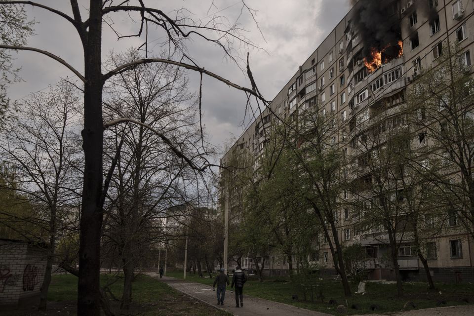 An apartment building on fire after it was hit during a Russian bombardment in Kharkiv (AP)