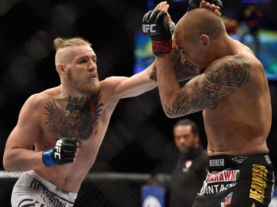 Conor McGregor punches Dustin Poirier in their featherweight fight during the UFC 178 in Las Vegas, Nevada in September 2014.