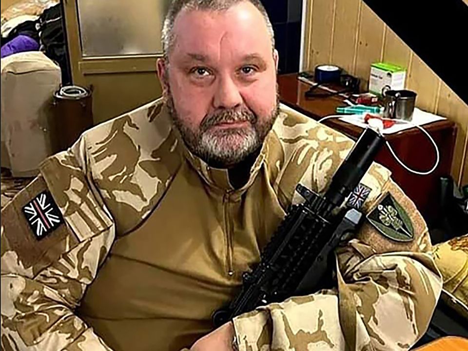 Pastor Clifford Peeples in Ukraine cradling a high-powered machine-gun